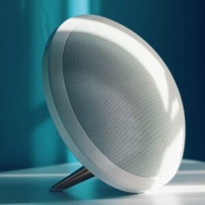 Close-up of a modern wireless speaker with a minimalist design, lit by natural light indoors. Ideal for tech product showcase.