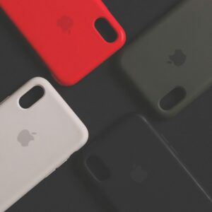 Four colorful smartphone cases on a dark surface, showcasing variety and design.
