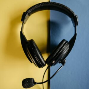 Close-up of a black headset with microphone on a contrasting yellow and blue backdrop.